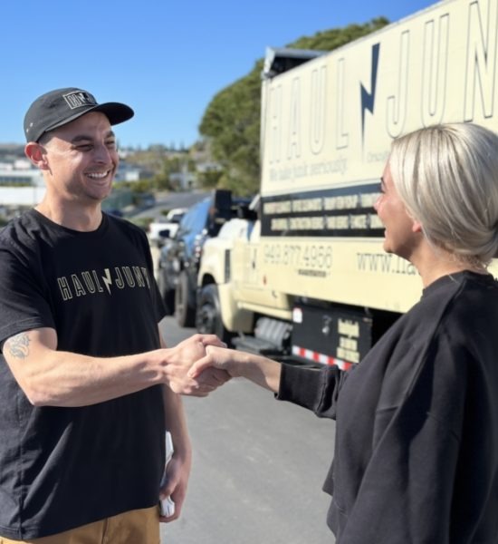 HaulNJunk owner shaking hands with a customer by the truck